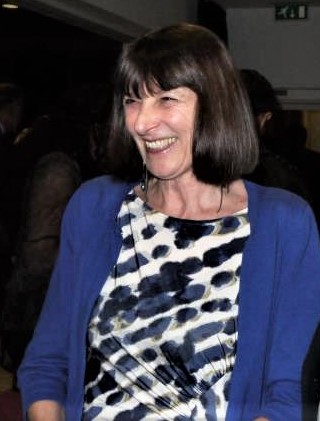 Lucy, smiling, in conversation with a person who is off camera